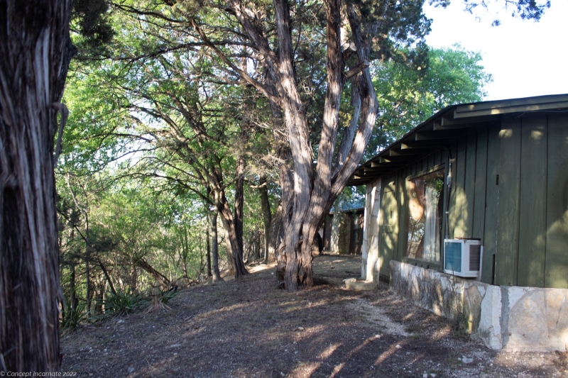 Outdoor view of cabins at sunset on cliff ledge.