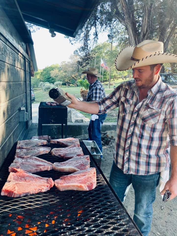 man adding seasoning to raw steaks man adding seasoning to raw steaks