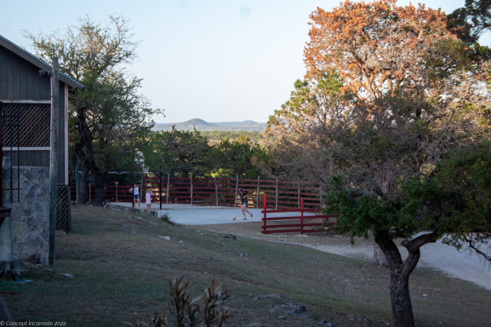Children playing soccer at scenic hillside.