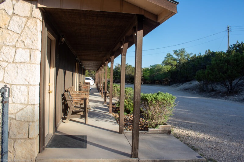 Outdoor shot of motel rooms, focused on wood benches.
